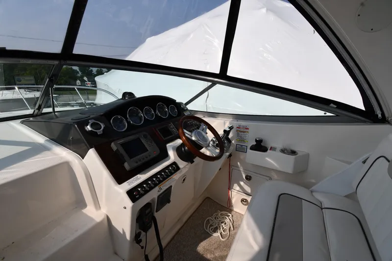 Slide: The Image of 2011 Sea Ray 310 Sundancer helm with steering wheel, gauges, and navigation equipment. - 11