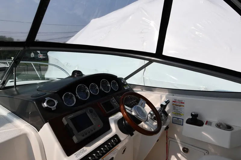Slide: The Image of Interior helm of 2011 Sea Ray 310 Sundancer boat with steering wheel and control panel. - 12