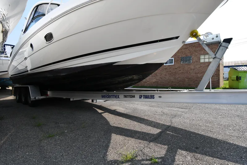 Slide: The Image of 2011 Sea Ray 310 Sundancer on a trailer, parked outdoors. - 3