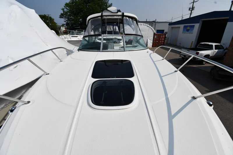 Slide: The Image of 2011 Sea Ray 310 Sundancer boat deck with railing and hatch, docked outdoors. - 32