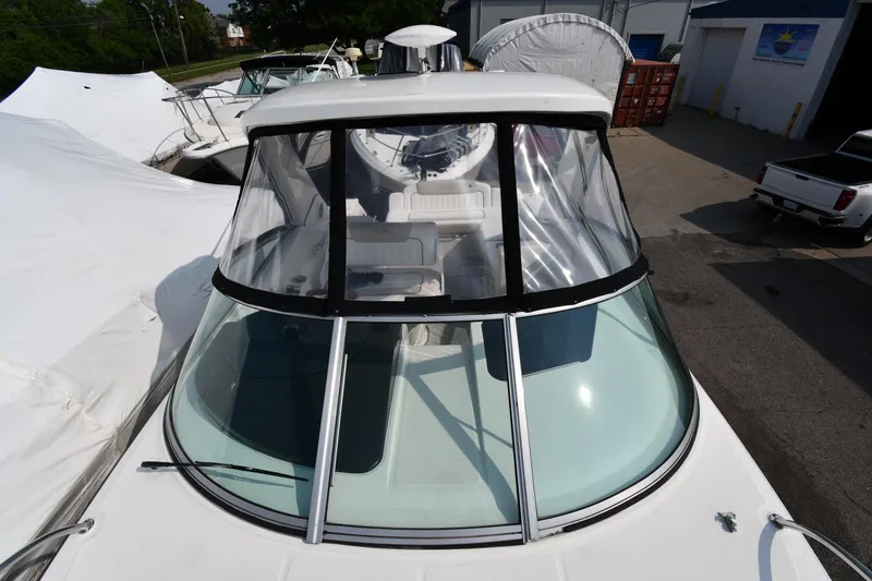 Slide: The Image of 2011 Sea Ray 310 Sundancer boat with clear cockpit enclosure, docked outdoors. - 34