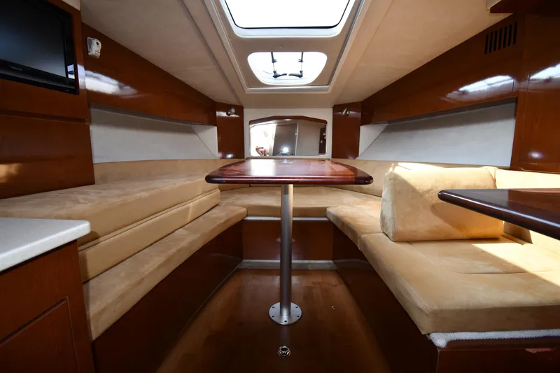 Slide: The Image of Interior of 2011 Sea Ray 310 Sundancer yacht with beige seating and wooden table. - 39