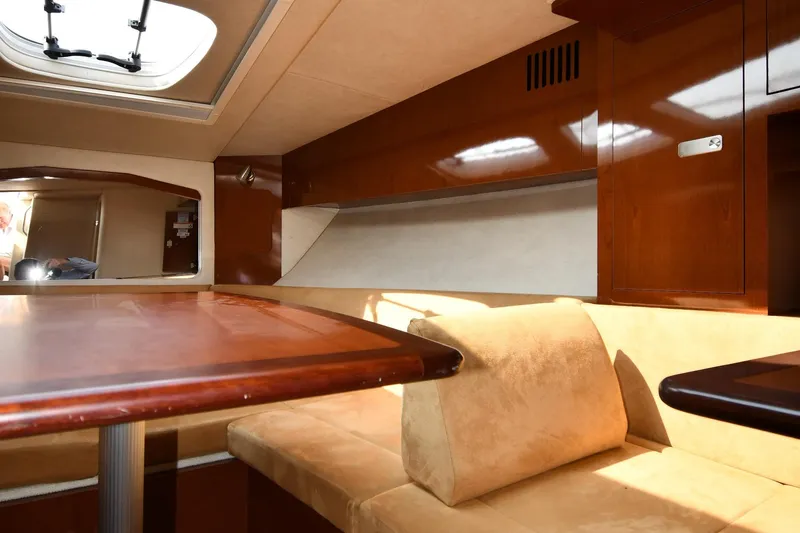 Slide: The Image of Interior of 2011 Sea Ray 310 Sundancer, featuring wood finishes and beige seating. - 40