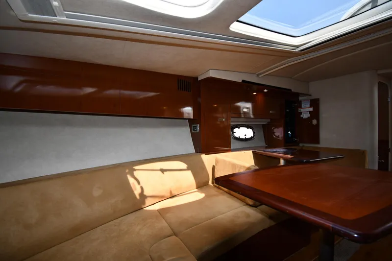 Slide: The Image of Interior of 2011 Sea Ray 310 Sundancer yacht with plush seating and wooden table. - 43