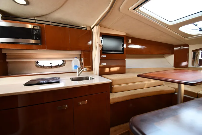 Slide: The Image of Interior of 2011 Sea Ray 310 Sundancer yacht with kitchenette and seating area. - 45