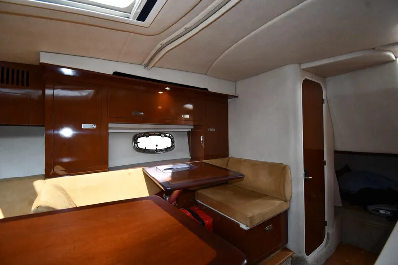 Slide: The Image of Interior of 2011 Sea Ray 310 Sundancer with wood cabinetry and beige seating. - 48