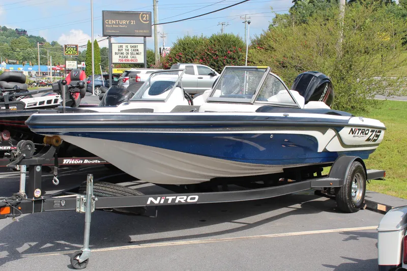 The Image of 2018 Nitro Z19 boat on trailer in parking lot, blue and white design. - 0
