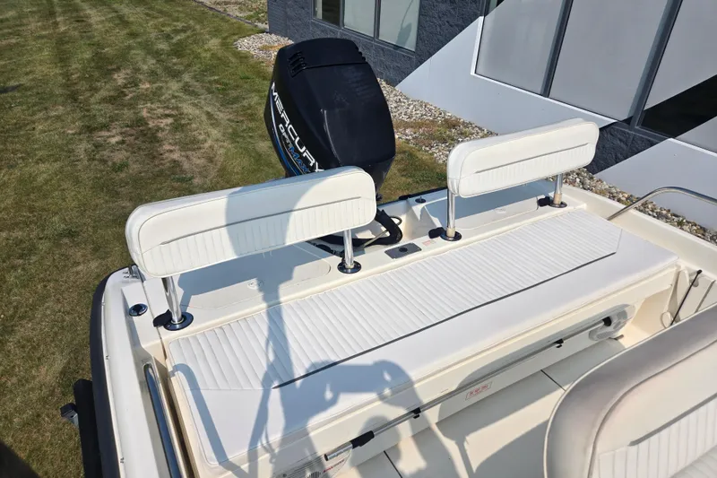 Slide: The Image of 1998 Boston Whaler 18 Dauntless boat with Mercury engine, featuring white seating and sleek design. - 12