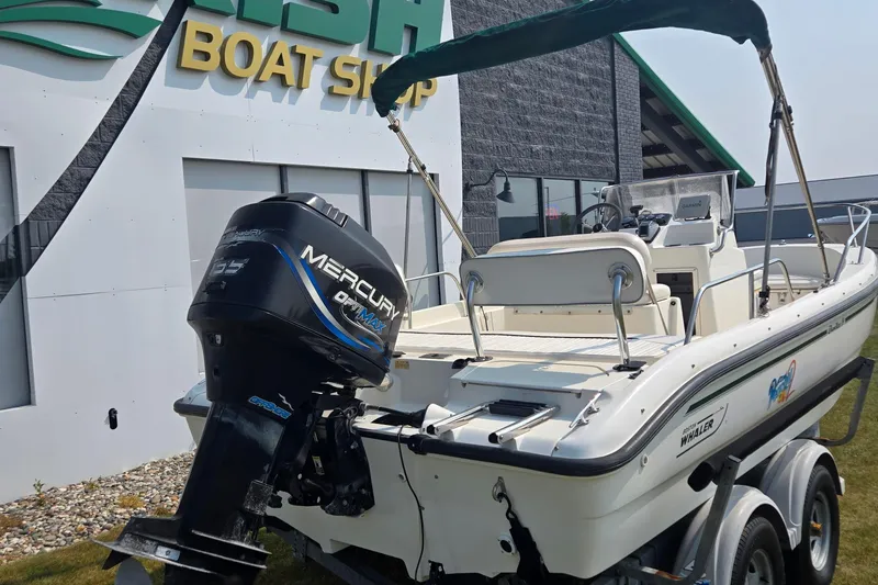 Slide: The Image of 1998 Boston Whaler 18 Dauntless boat with Mercury outboard motor at a boat shop. - 5
