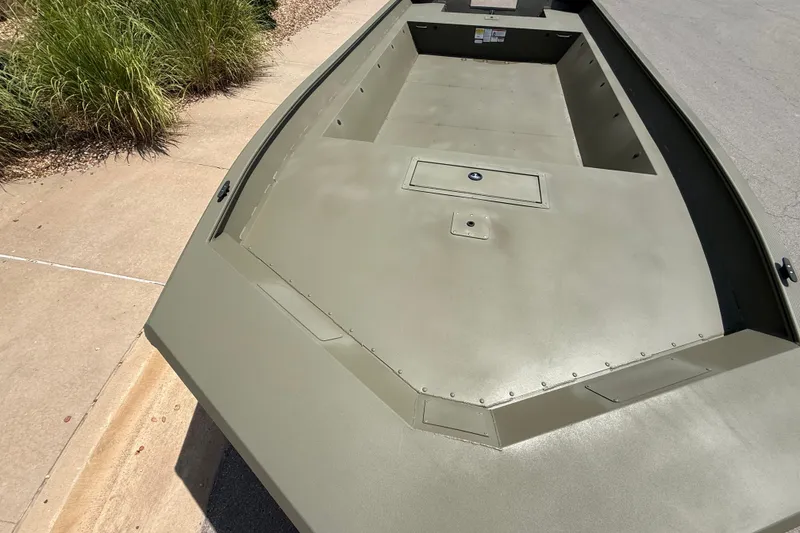 Slide: The Image of 2026 Tracker Grizzly 2072 Utility boat with spacious deck, parked on concrete surface. - 2