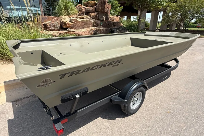 Slide: The Image of 2026 Tracker Grizzly 2072 Utility boat on trailer, outdoors with greenery background. - 6