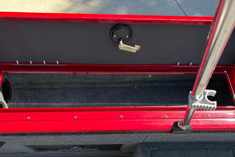 Slide: The Image of 2026 Tracker Targa V-18 WT boat storage compartment with red trim and secure locking mechanism. - 28