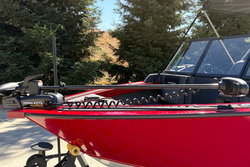 Slide: The Image of Red 2026 Tracker Targa V-18 WT boat with Minn Kota PowerDrive motor, parked outdoors. - 8