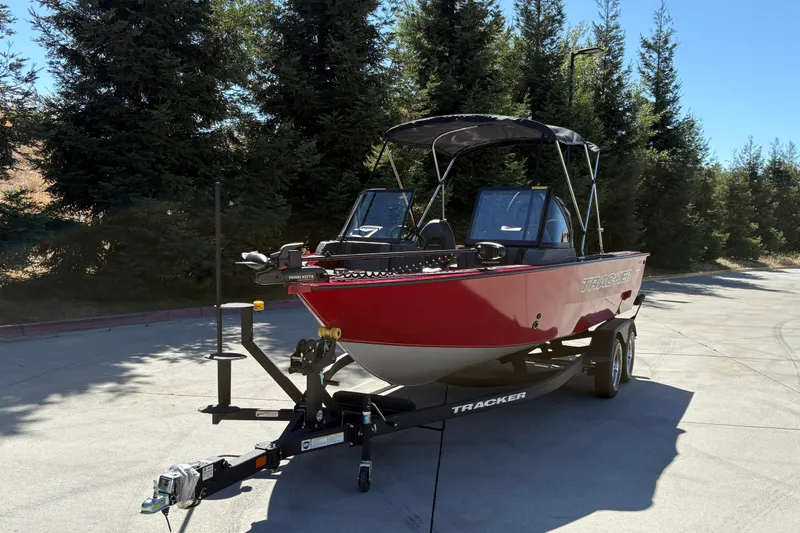 Slide: The Image of 2026 Tracker Targa V-18 WT boat on trailer, parked outdoors with trees in background. - 6