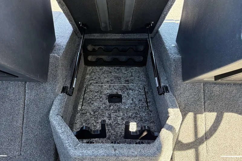 Slide: The Image of 2026 Tracker Targa V-18 WT boat storage compartment with carpeted interior and hydraulic lifts. - 44