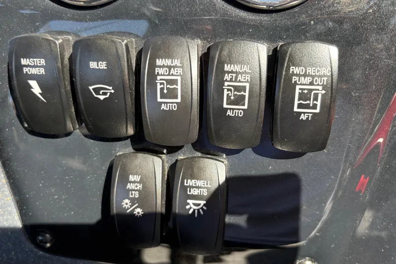 Slide: The Image of Control panel switches on a 2026 Tracker Targa V-18 WT boat dashboard. - 22