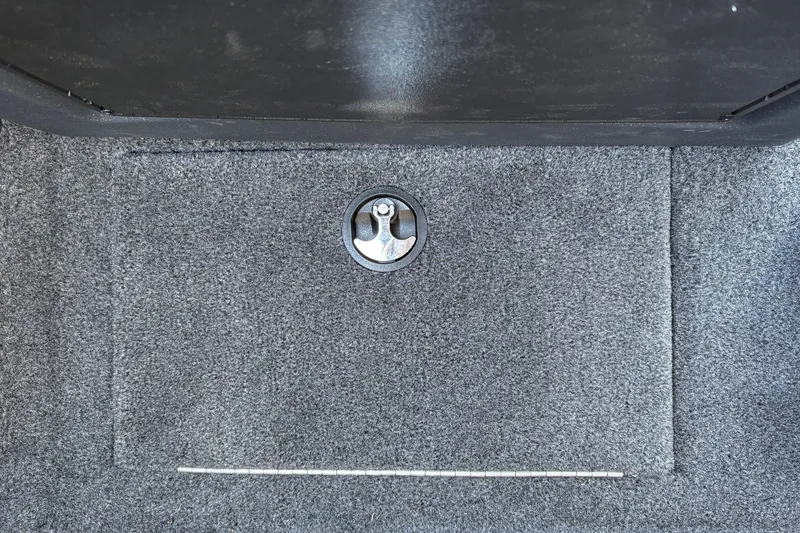Slide: The Image of 2026 Tracker Targa V-18 WT carpeted storage compartment with metal latch detail. - 50
