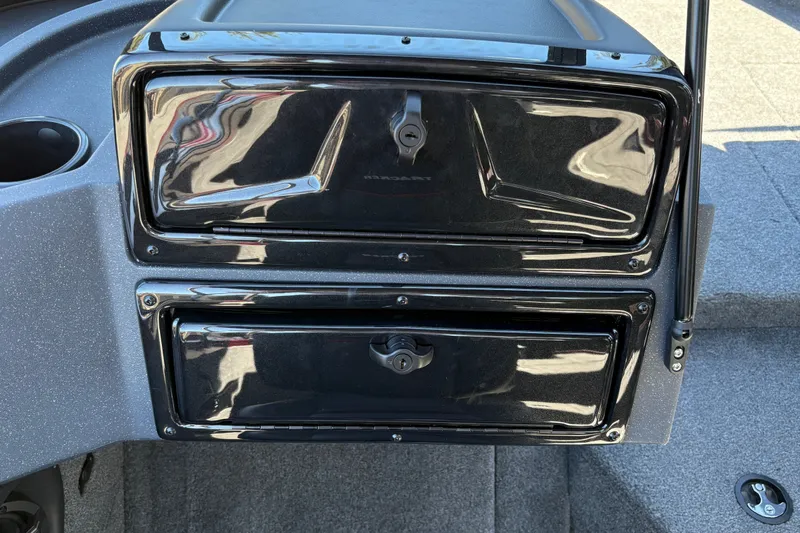 Slide: The Image of 2026 Tracker Targa V-18 WT boat dashboard with storage compartments and sleek black finish. - 24