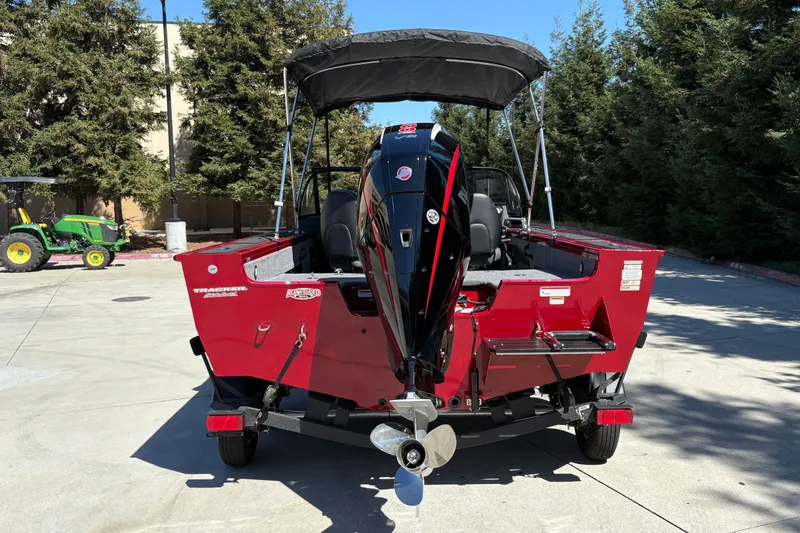 Slide: The Image of 2026 Tracker Targa V-18 WT boat with outboard motor, parked outdoors. - 9