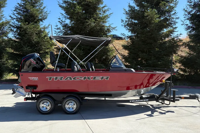 The Image of 2026 Tracker Targa V-18 WT boat on trailer, parked outdoors with trees in background. - 0