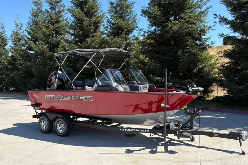 Slide: The Image of 2026 Tracker Targa V-18 WT boat on trailer, parked outdoors near trees. - 3