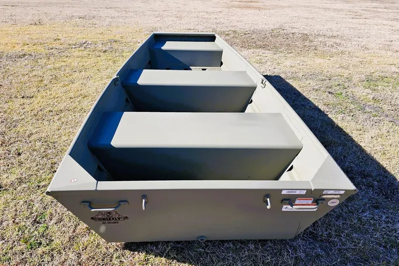 Slide: The Image of 2026 Tracker Grizzly 10 Jon boat on grass, showcasing its sturdy design and spacious interior. - 1