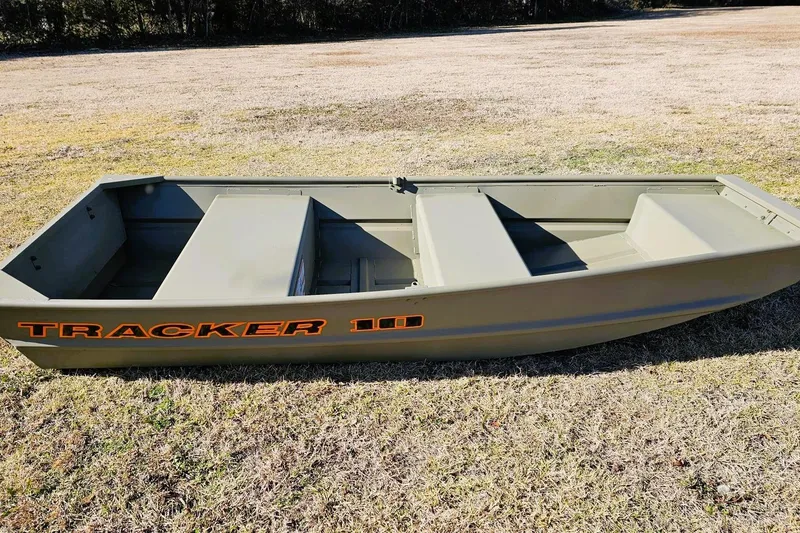 Slide: The Image of 2026 Tracker Grizzly 10 Jon boat on grassy field, showcasing durable design. - 3