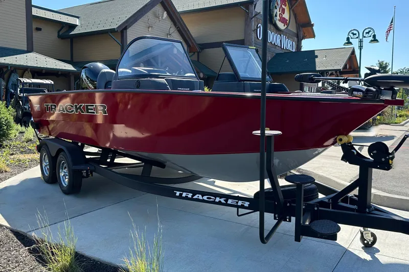 Slide: The Image of 2026 Tracker Targa V-18 WT boat on trailer, parked outside a store. - 19