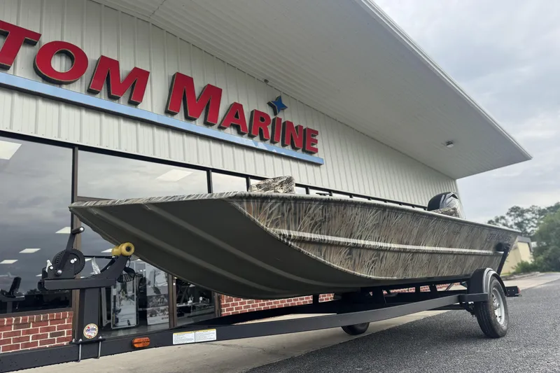 Slide: The Image of 2026 Tracker Grizzly 1754 SC boat on trailer outside marine store. - 41