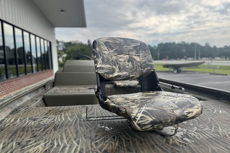 Slide: The Image of 2026 Tracker Grizzly 1754 SC boat with camo seat, parked outdoors. - 43