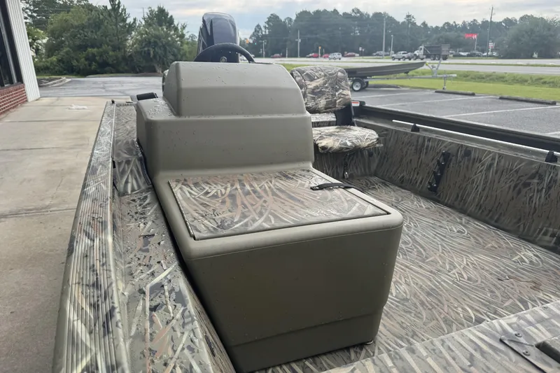 Slide: The Image of 2026 Tracker Grizzly 1754 SC boat with camouflage interior, parked outdoors. - 44