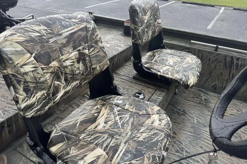 Slide: The Image of 2026 Tracker Grizzly 1754 SC boat interior with camo-patterned seats and wet surfaces. - 45