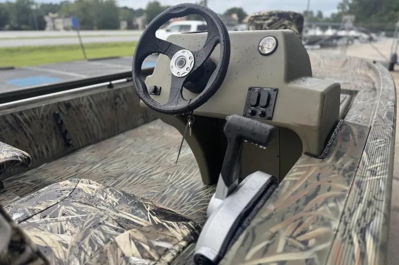 Slide: The Image of 2026 Tracker Grizzly 1754 SC boat interior with camo seats and steering console. - 46