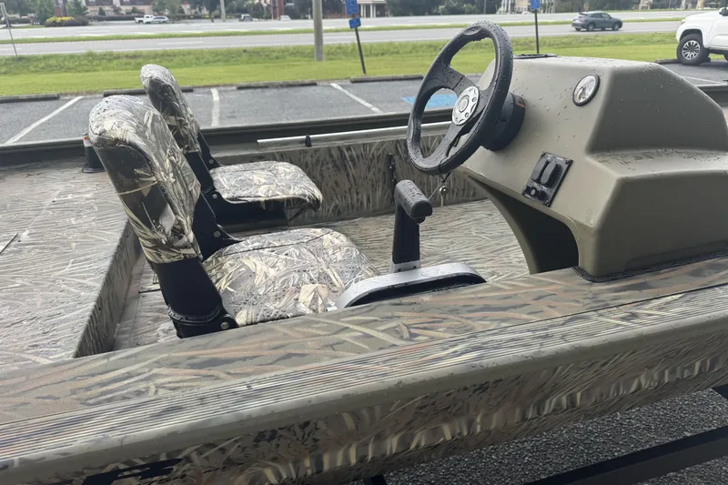 Slide: The Image of 2026 Tracker Grizzly 1754 SC boat interior with camouflage seats and steering console. - 49