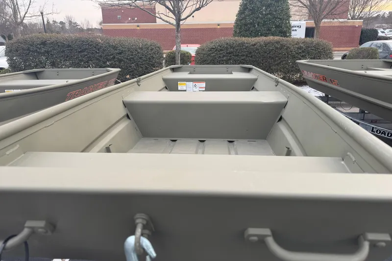 Slide: The Image of 2026 Tracker Grizzly 14 Jon boat, parked outdoors, showcasing interior seating and design. - 3