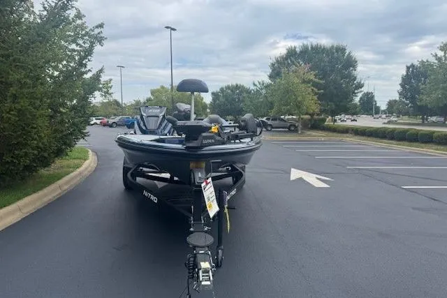 Slide: The Image of 2026 Nitro Z18 Pro boat parked in a lot, surrounded by trees and cloudy sky. - 2