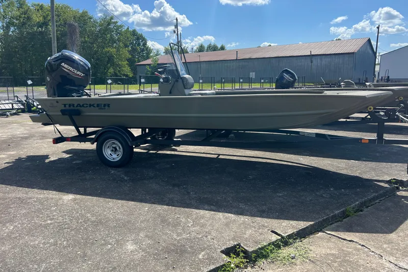 The Image of 2026 Tracker Grizzly 1860 CC boat on trailer, outdoors under blue sky. - 0