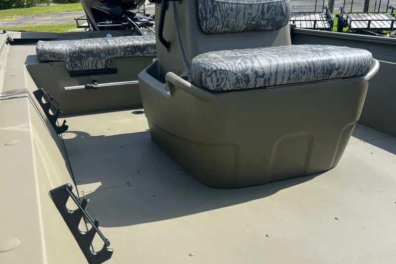 Slide: The Image of 2026 Tracker Grizzly 1860 CC boat interior with camouflage seating and storage compartments. - 4