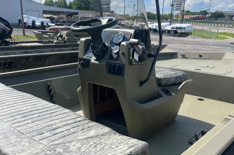 Slide: The Image of 2026 Tracker Grizzly 1860 CC boat interior with steering console and seating. - 5