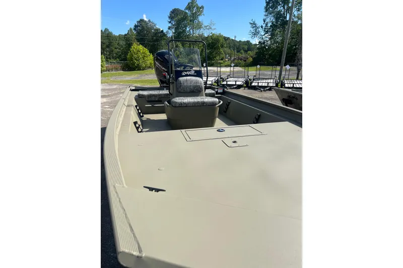 Slide: The Image of 2026 Tracker Grizzly 1860 CC boat with seating and console, outdoors on a sunny day. - 9