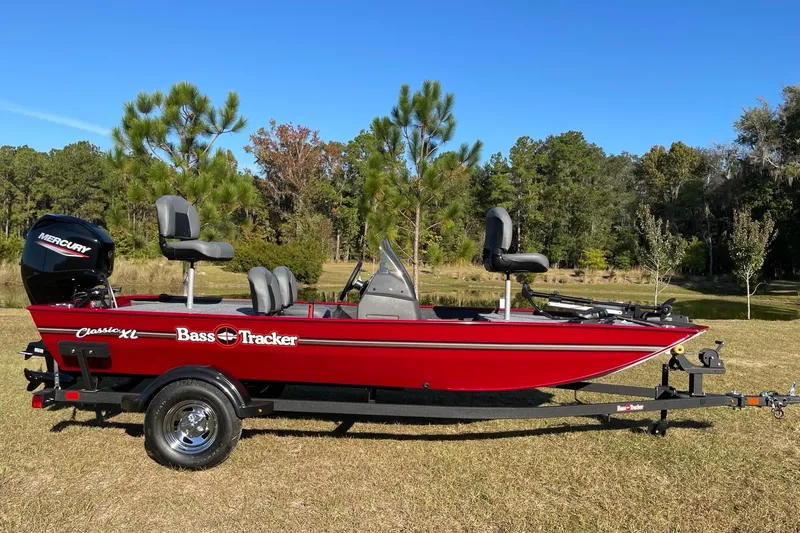 The Image of 2026 Tracker Bass Tracker Classic XL boat on trailer, red color, outdoor setting. - 0