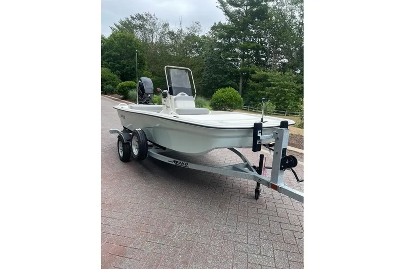Slide: The Image of 2026 Mako Pro Skiff 13 CC boat on trailer, parked on brick driveway. - 2