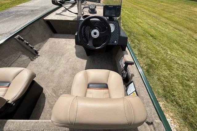 Slide: The Image of 2026 Tracker Bass Tracker Classic Limited boat interior with steering wheel and beige seats. - 2