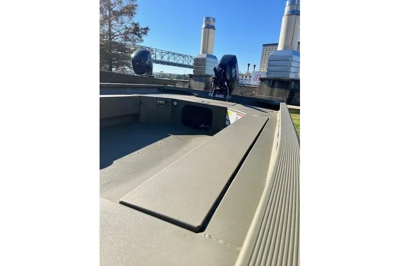 Slide: The Image of 2026 Tracker Grizzly 1654 T Sportsman boat, outdoor setting, clear sky, industrial background. - 41