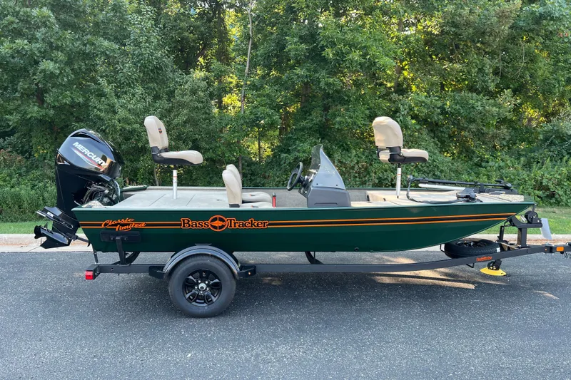 The Image of 2026 Tracker Bass Tracker Classic Limited boat on trailer, parked on road with trees in background. - 0