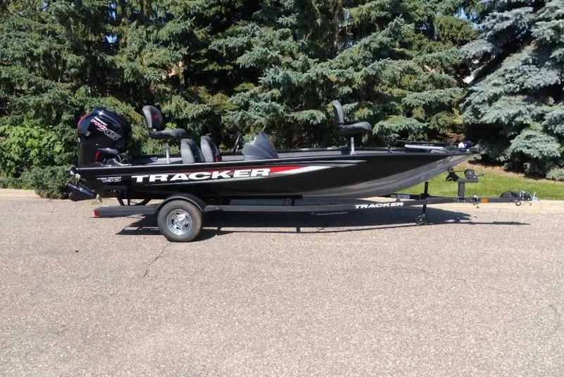 The Image of 2026 Tracker Pro Team 190 boat on trailer, parked outdoors with trees in background. - 0