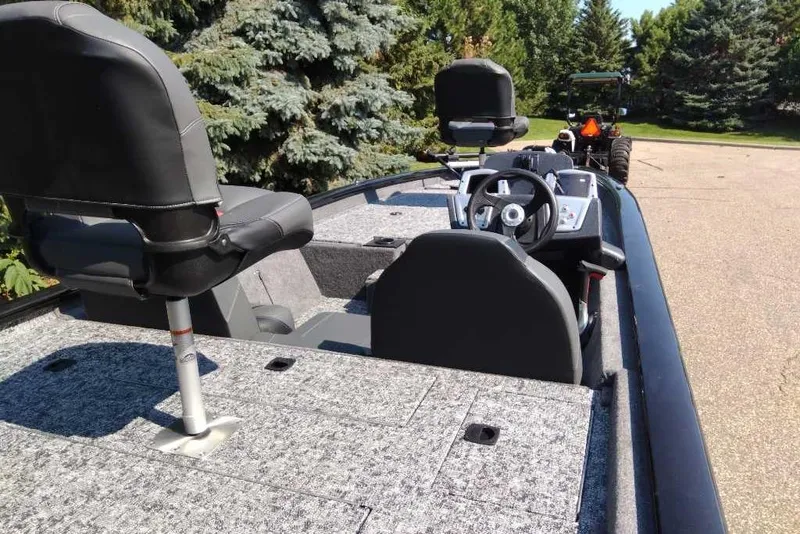 Slide: The Image of 2026 Tracker Pro Team 190 boat interior with steering wheel and seating, parked outdoors. - 3