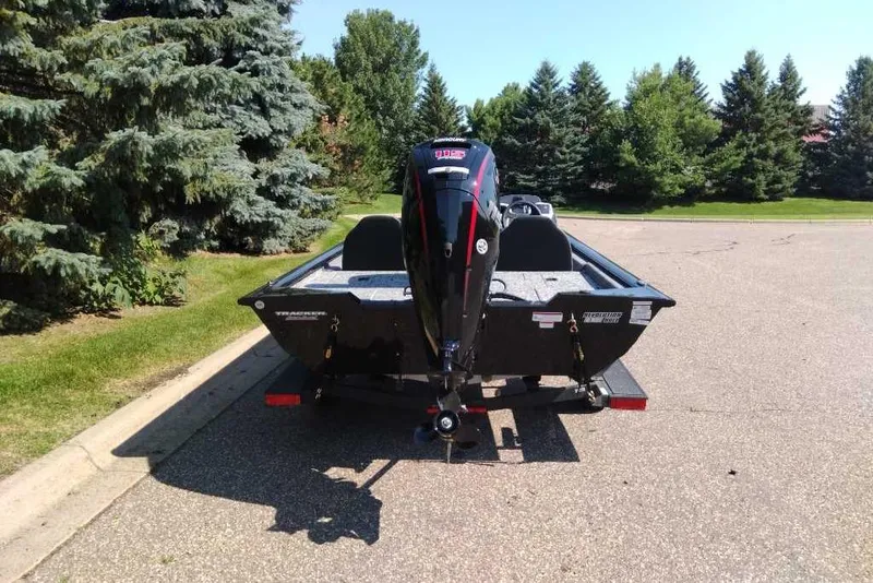 Slide: The Image of 2026 Tracker Pro Team 190 boat on trailer, parked near trees. - 5