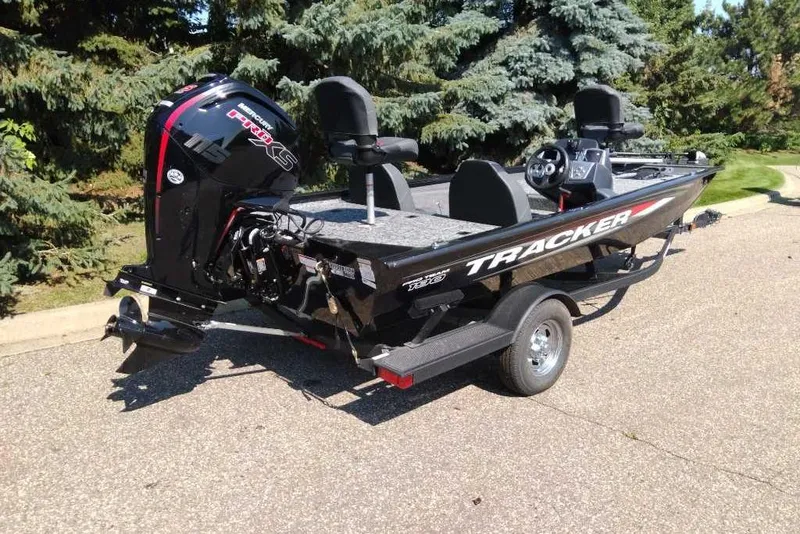 Slide: The Image of 2026 Tracker Pro Team 190 boat on trailer, parked outdoors near trees. - 6