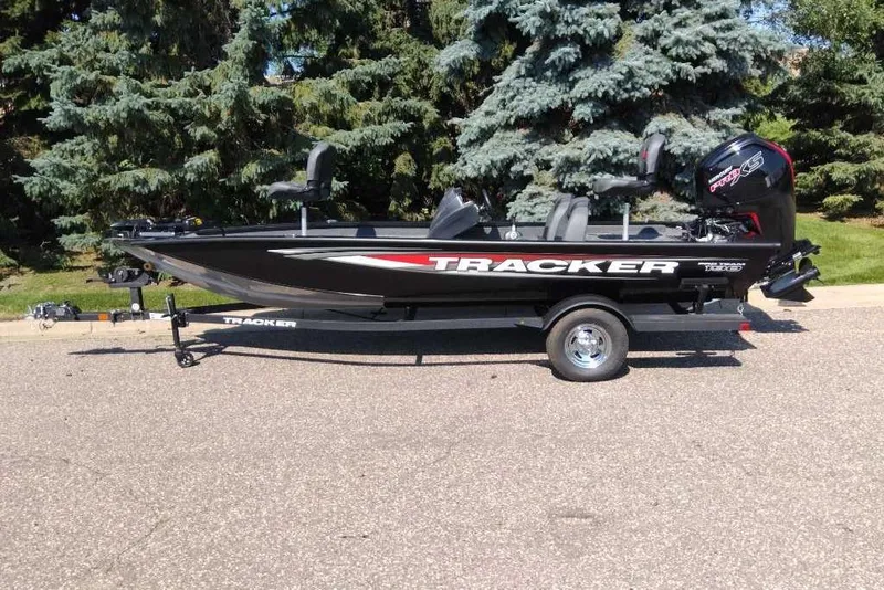 Slide: The Image of 2026 Tracker Pro Team 190 boat on trailer, parked outdoors with trees in background. - 8